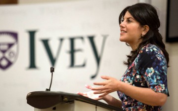 Image of a woman speaking into a microphone with an Ivey banner in the background