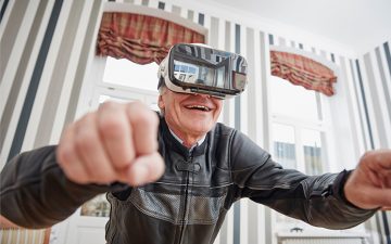 Image of an older man wearing a VR headset and smiling