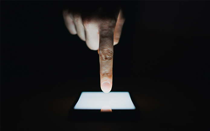 Close up of woman's hand using smartphone in the dark