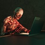 Horror Zombie with flaking flesh using laptop computer in dark room.