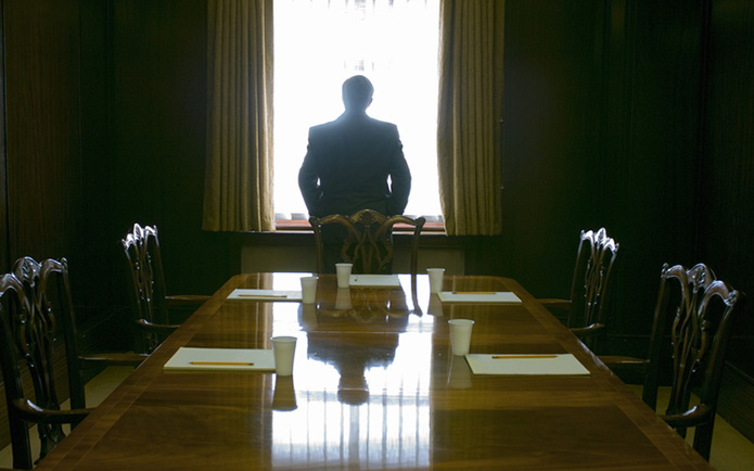 Businessman-Facing-Window-In-Meeting-Room-Rear-View
